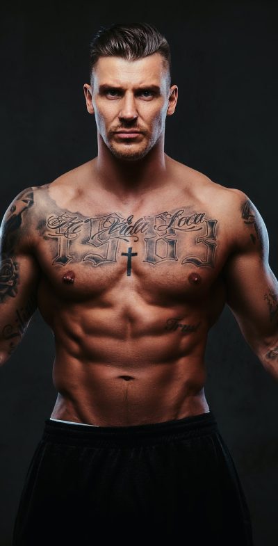 a-muscular-tattooed-man-on-a-dark-background-.jpg